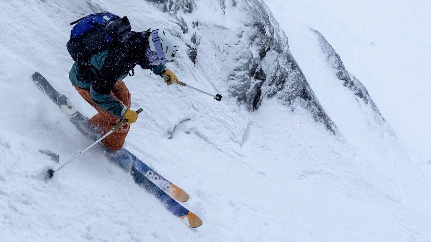 Person skiing down a steep, snow-covered mountain